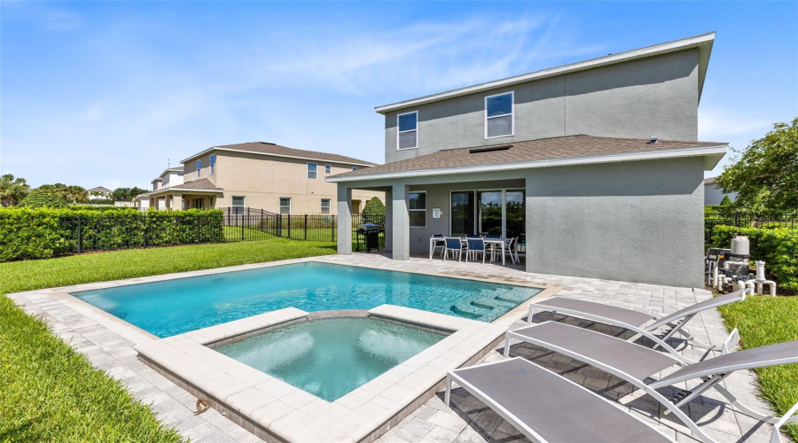 Paved and heated private pool/spa oasis with a covered paved patio and grill, great for relaxing and entertaining.