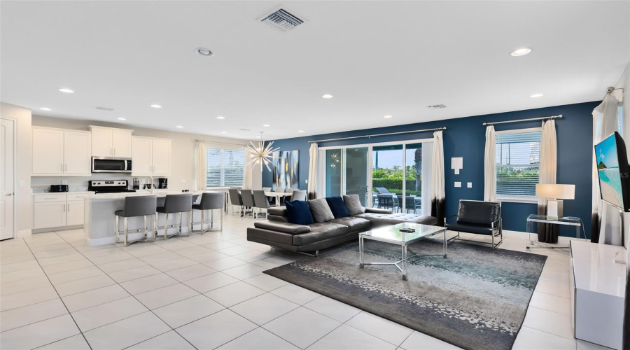 The kitchen is open to the spacious living room with sliders that open to the luxury paves and heated private pool/spa oasis, great for relaxing and entertaining.