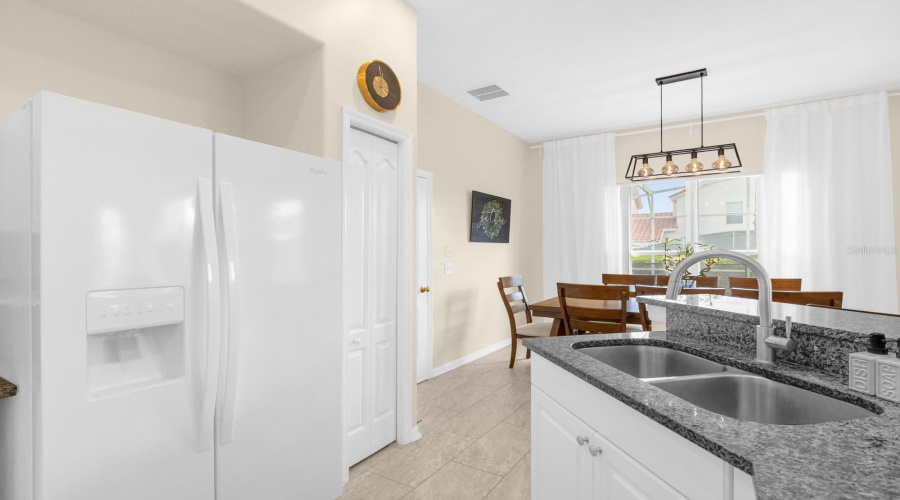 Kitchen Area Has White Appliances And Solid Stone Counters