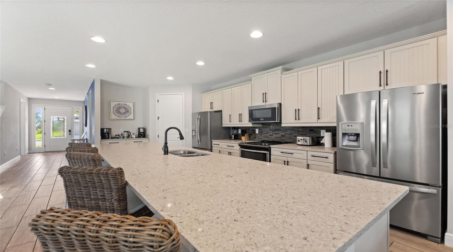 A View Of The Kitchen, Coffee Bar, Pantry, And Entry Way.