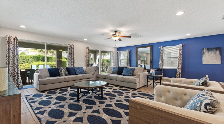 An Inviting Gathering Space With Natural Lighting Between The Sliding Glass Doors And The Windows.