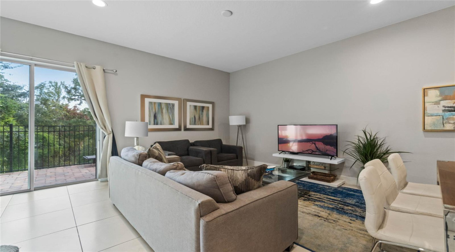 Sliding Doors In The Great Room Lead Out To The Paved Patio With Tranquil Wooded Views