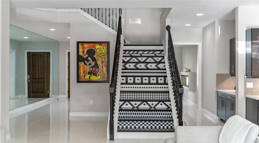 This Two Story Home Features A Dramatic Artistic Wood And Iron Grand Staircase.