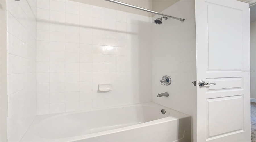 A view of the clean shower and tub.