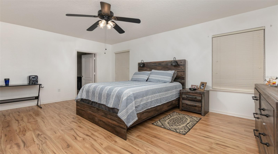 Oversized Primary Bedroom With Laminate Flooring, Ceiling Fan And En Suite Primary Bathroom.