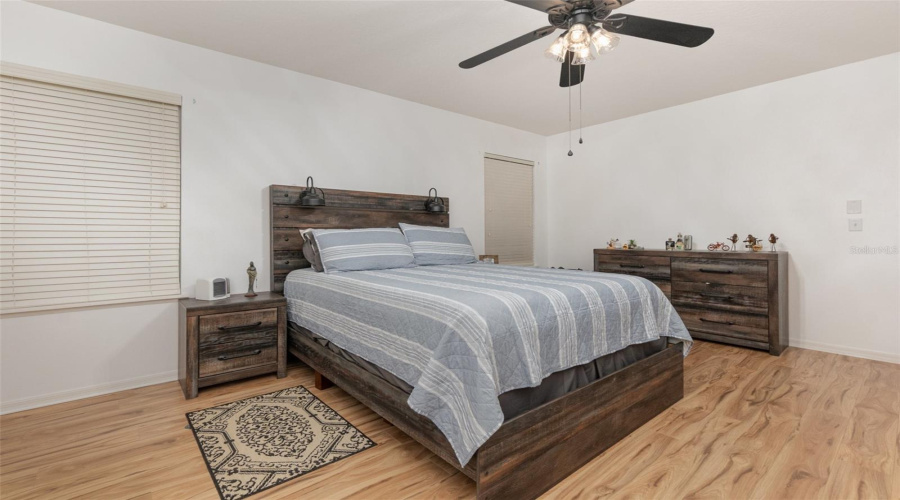 Oversized Primary Bedroom With Laminate Flooring, Ceiling Fan And En Suite Primary Bathroom.