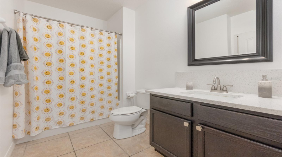 Tiled Guest Bathroom With White Quartz Counters.