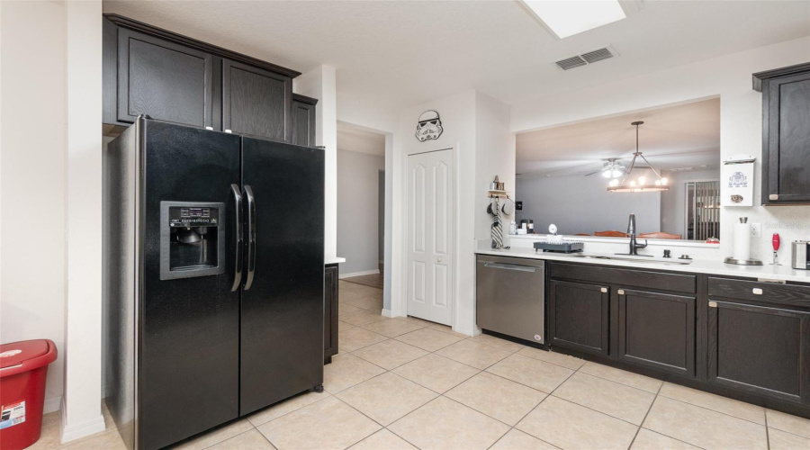 Tiled Kitchen Features White Quartz Counters And Breakfast Bar, Modern Black Appliances And Stainless Steel Dishwasher And Bay Window With Large Dinette Eating Space.