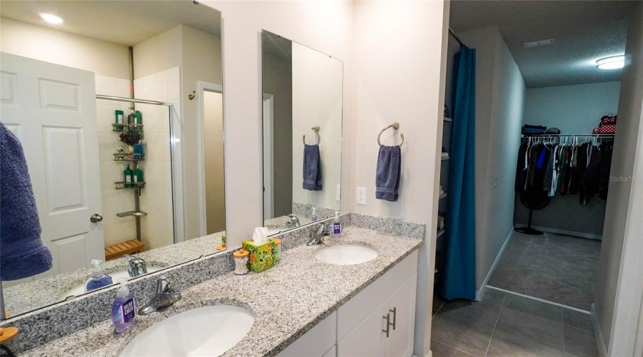 First Floor Ensuite Primary Bath Features A Large Vanity With A Granite Countertop And Dual Sinks, A Large Shower, A Large Linen Closet And A Separate Toilet Room.