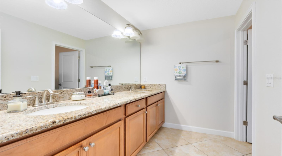 2nd bathroom with dual vanities and tub with shower.