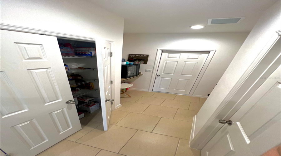 Pantry, half bathroom, coffee or wine area, and garage door.