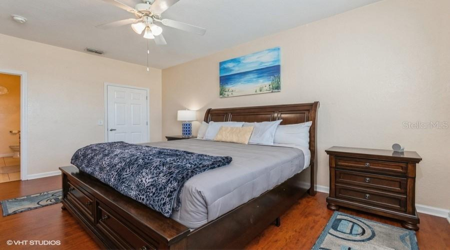 The Generously Sized Primary Bedroom Showcases Warm Laminate Flooring, A Walk-In Closet, And A Private En Suite Bath, And Is Tastefully Furnished With A Sleigh Bed And Coordinating Chest Of Drawers And Nightstands.