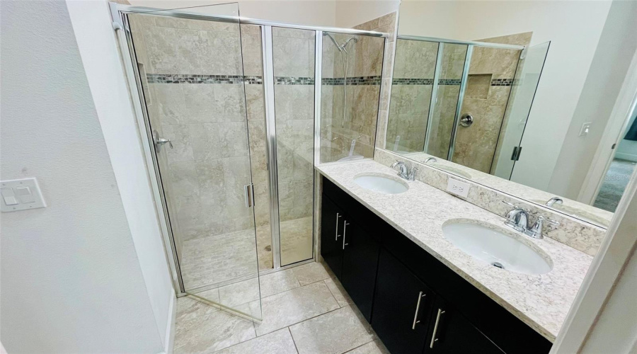 Downstairs Primary Bathroom With Dual Sinks And Walk In Shower