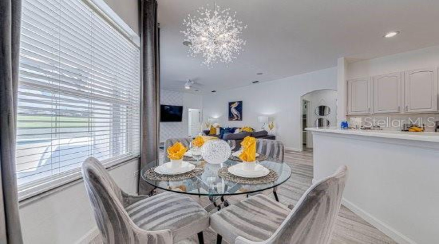 Kitchen Nook Sits Beautifully Close To Kitchen And Window Over Looking Pool And Fairways With Modern Chandelier.