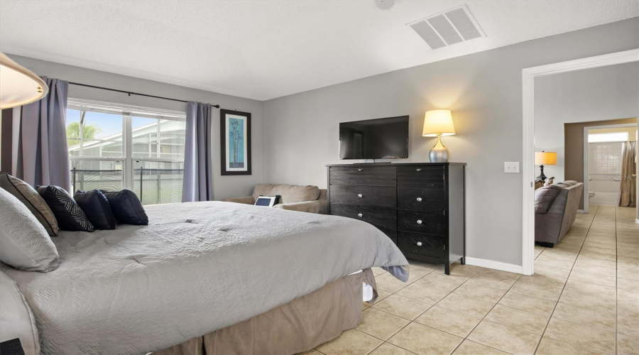 Spacious primary bedroom at the back of the home near pool