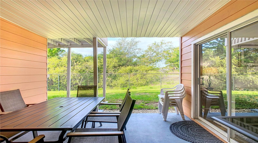 Private outdoor space. Covered lanai. Solid ceiling to prevent dirt and debris from falling through, added by seller. Property backs to wooded area - no rear neighbors. Sliding door access to both ensuite bedrooms.
