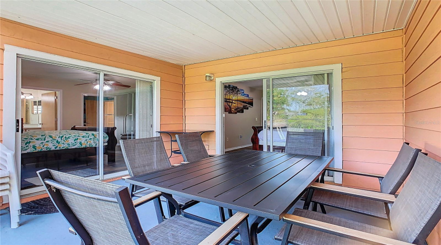 Private outdoor space. Covered lanai. Solid ceiling to prevent dirt and debris from falling through, added by seller. Property backs to wooded area - no rear neighbors. Sliding doors access to ensuite bedrooms.