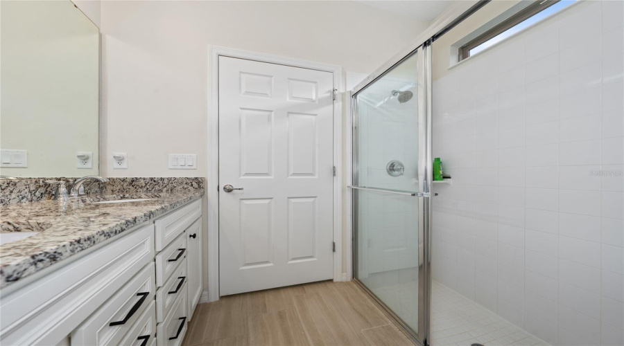 Primary Ensuite Bathroom With Dual Sinks And Enclosed Shower With Transom Window