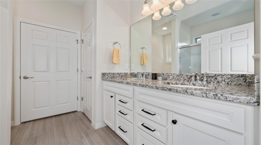 Primary Ensuite Bathroom With Walk-In Closet (Center), Towel Closet (Right) And Toilet (Left)