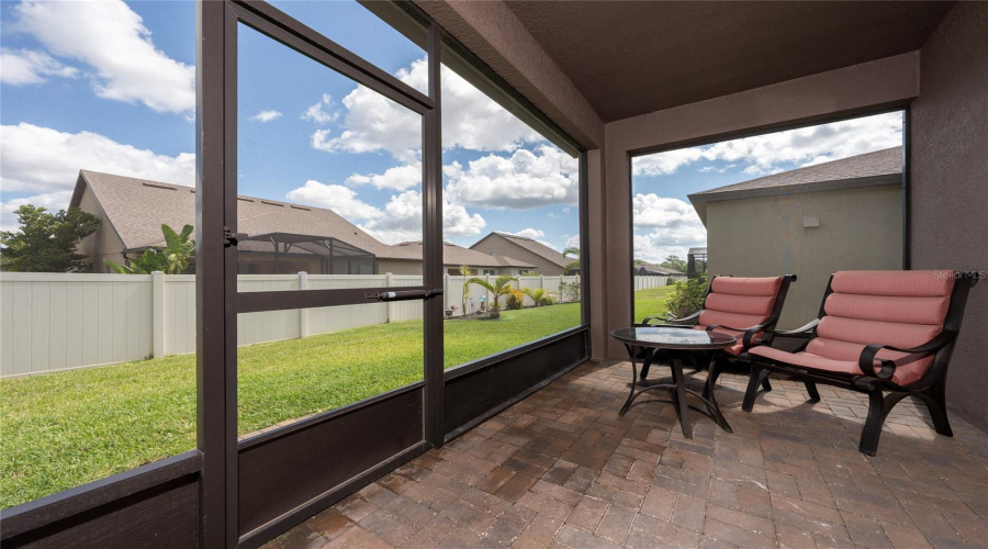 Covered Screened Lanai With Brick Pavers At Back Of Home