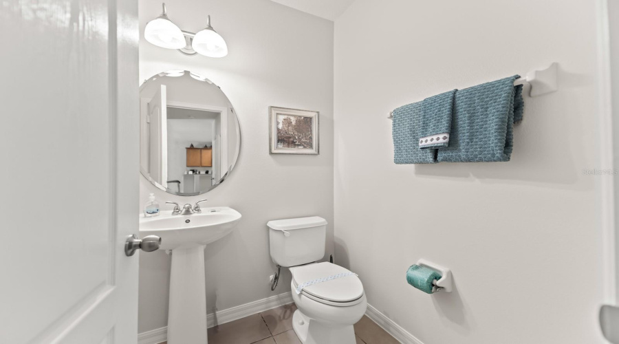 Half Bathroom Sits At The End Of The Corridor Leading To The Downstairs Primary Bedroom