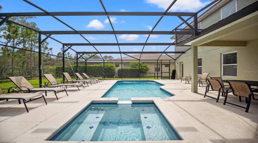 Extended Pool Deck With Resort Style Pool Sits Alongside Covered Lanai
