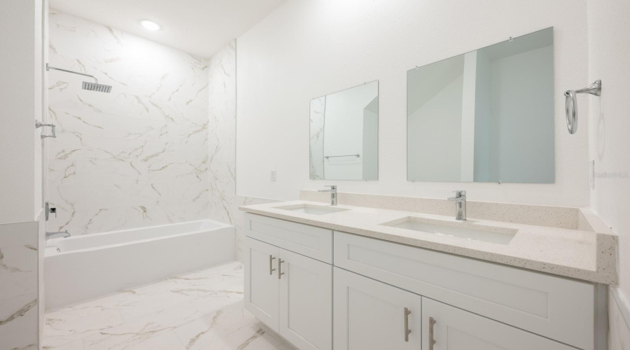 The first-floor Master Suite includes a well-appointed en suite Bathroom with double sinks and a tub/shower combination topped with a relaxing rain shower head.