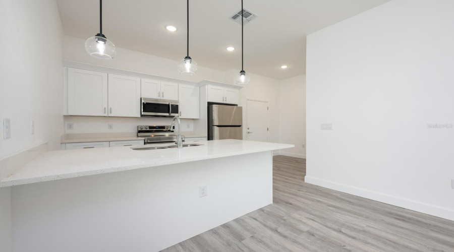 The Kitchen island is designed to accommodate counter-height stools, adding both function and casual seating.