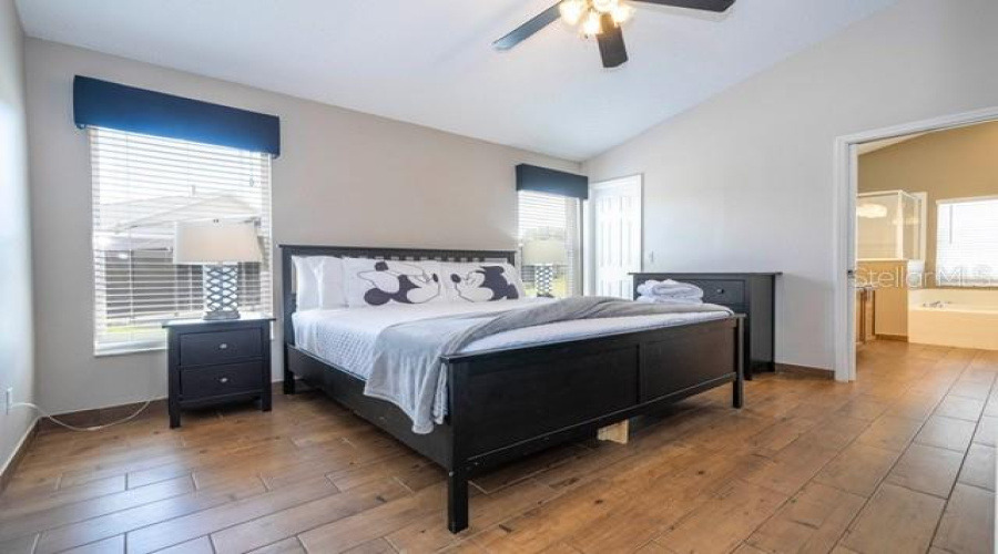 Primary Master Suiteeaturing a king-size bed, private en-suite bathroom, and direct access to the pool area.