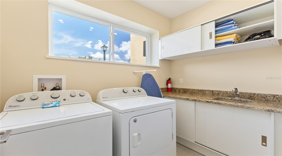 Laundry with laundry sink downstairs.