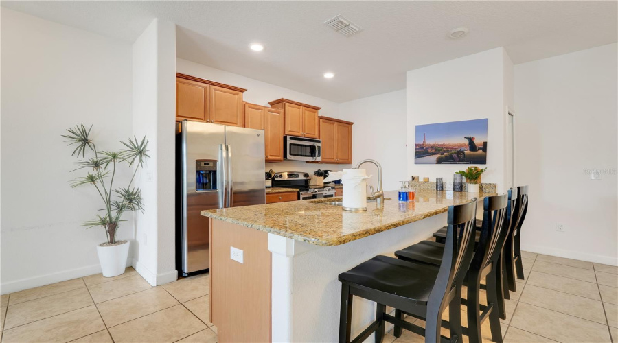 Kitchen with bar stools and granite countertops