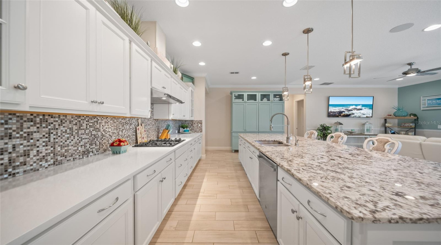 Bright, open kitchen with huge island, gas cooktop, and sleek finishes perfect for daily life or hosting.