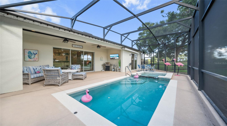 Enjoy golf course views from your screened-in lanai with private pool, spa, and outdoor TV setup.