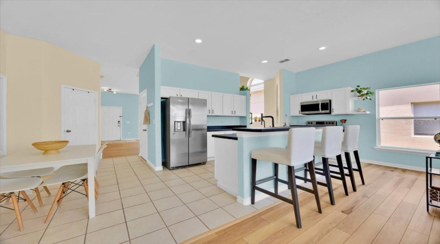 This bright kitchen offers not just beauty, but everyday convenience-with a closet pantry across the dining area and a second walk in one tucked under the stairs.Esta cocina luminosa combina estilo y funcionalidad-con una despensa al frente del comedor y un amplio closet debajo de las escaleras.