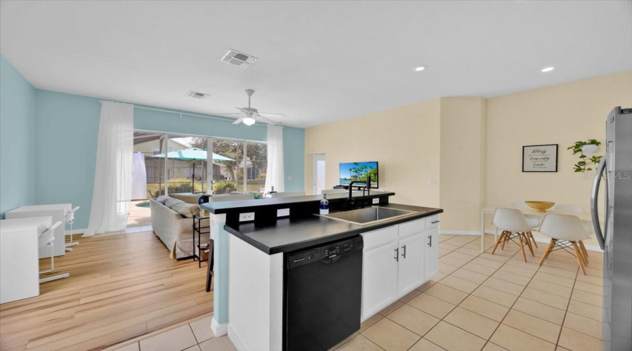 From the kitchen, enjoy a clear view of the living room, pool area, and patio-perfect for staying part of the fun while grabbing a snack or drink. Wheather entertaining or enjoying movie night with the family, this layout keeps you connected. And no carpet here-just gorgeous, easy care flooring throughot!Desde la cocina, disfruta de una visa despejada hacia la sala, el area de la piscina y el patio-perfecto para seguir conectado mientras preparas algo para tomar of comer. Ya sea recibiendo invitados o viendo peliculas en familia, este diseño lo hace todo mas facil. Y lo mejor: sin alfombra, solo pisos modernos y practicos en todo el hogar.