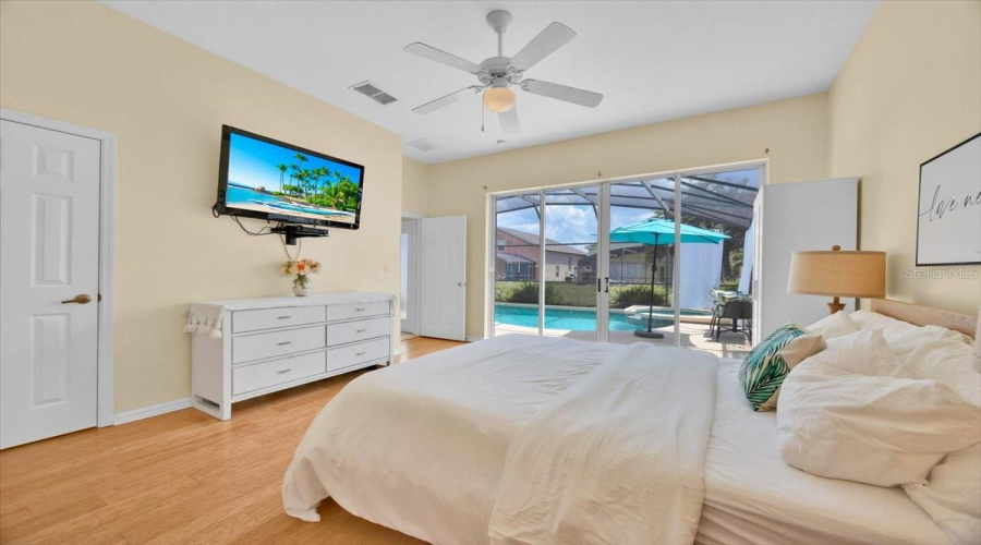 Wake up to views of the sparkling pool just steps away from your bed. This private suite offers direct access to the screened patio and pool area, creating the perfect indoor-outdoor Florida lifestyle. Whether for guests or short-term stays, it’s a serene retreat with a resort-like feel.Despierta con vista directa a la brillante piscina, a solo unos pasos de tu cama. Esta suite privada ofrece acceso directo al área de la piscina y terraza cubierta, creando el estilo de vida interior-exterior ideal de Florida. Perfecta para huéspedes o estancias cortas, es un refugio sereno con un ambiente tipo resort.