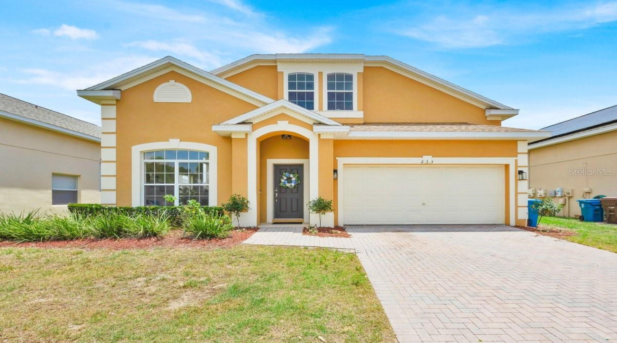A Florida Home That Blooms with Charm-African Lilies Grace the Entry Every Spring and Summer.Un hogar en Florida que florece con encanto - Lirios africanos adornan la entrada cada primaverya y verano.