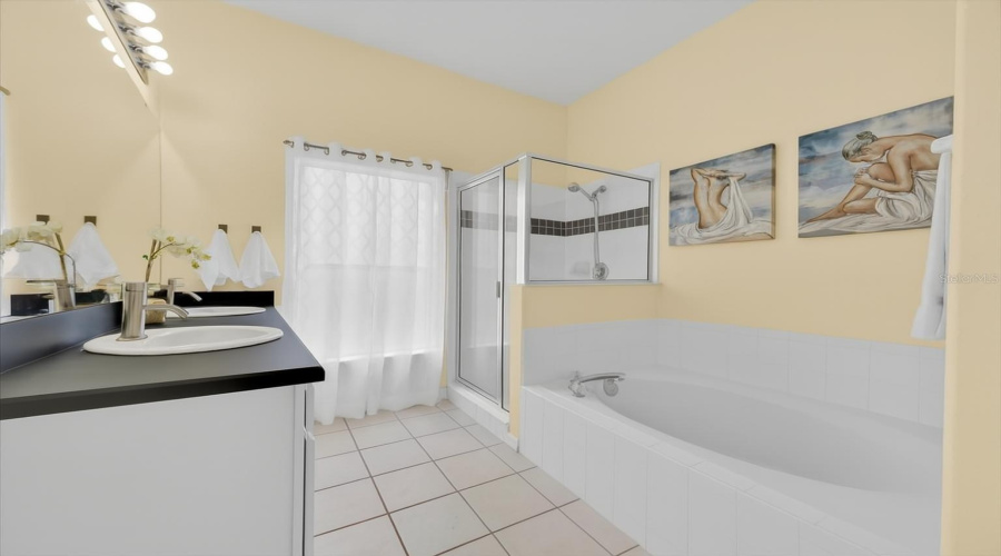 Guest/In-Law Suite Bathroom:This en-suite bathroom features a walk-in shower, separate soaking tub, private water closet with door, and a linen closet for extra storage. The double vanity and modern finishes create a clean, comfortable space ideal for guests or in-laws.ESPAÑOL:Baño de la Suite de Invitados o Suegros:Este baño en-suite cuenta con ducha tipo walk-in, bañera independiente, sanitario privado con puerta y clóset de ropa blanca. El tocador doble y los acabados modernos ofrecen un espacio cómodo y acogedor para invitados o familiares.