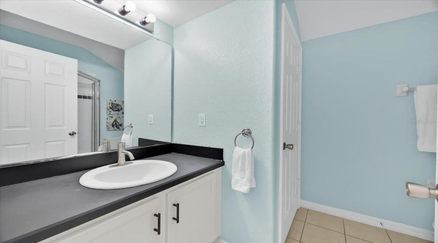 Upstairs Shared Bathroom:Bright and functional, this upstairs bathroom features calming blue walls and a sleek walk-in shower. Designed to be shared, it offers a practical layout with updated finishes, a spacious vanity, and easy access for family or guests.ESPAÑOL:Baño Compartido en el Segundo Piso:Luminoso y funcional, este baño en el segundo piso cuenta con paredes en tono azul suave y una moderna ducha tipo walk-in. Su diseño compartido ofrece un espacio práctico con acabados actualizados, tocador amplio y acceso cómodo para la familia o invitados.