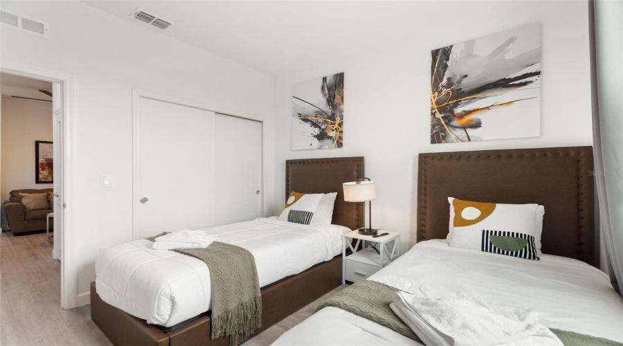 Bedroom 3 with two twin sized beds and flat screen TV.