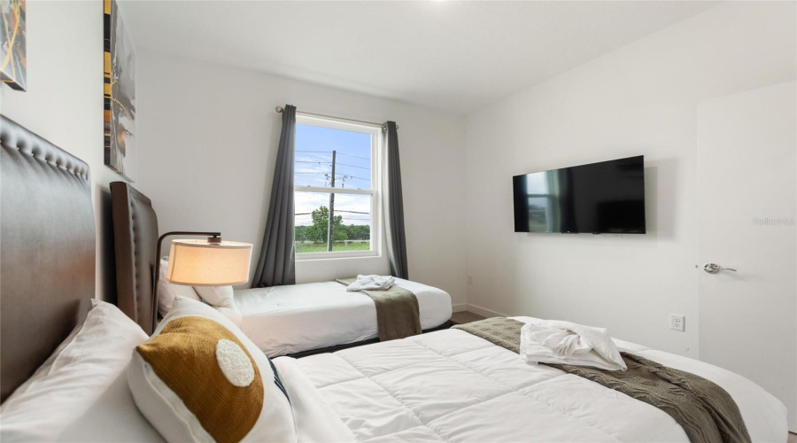 Bedroom 3 with two twin sized beds and flat screen TV.