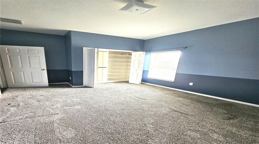 Bedroom 4 with Custom Closet Built-ins & View of Backyard