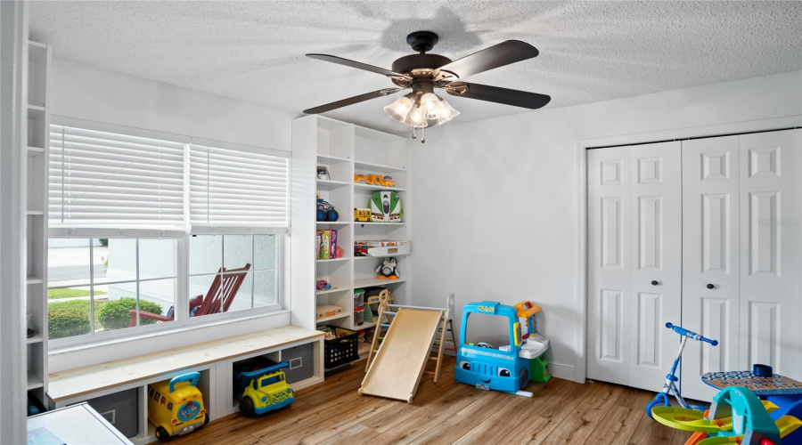This guest bedroom faces the front of the home and has built-in shelves.