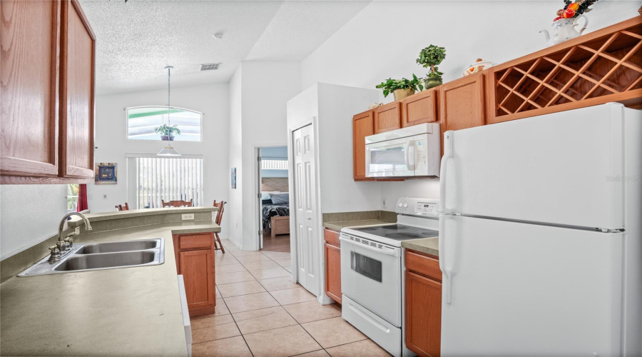 Looking from the kitchen to the kitchenette and into the primary bedroom.
