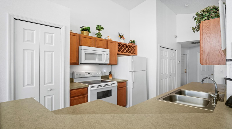The kitchen has a pantry closet, and to the right of the refrigerator is the laundry area.
