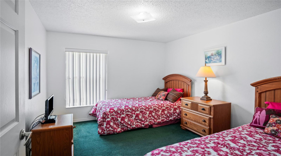 One of the guest bedrooms located off of the kitchen and near the primary suite.