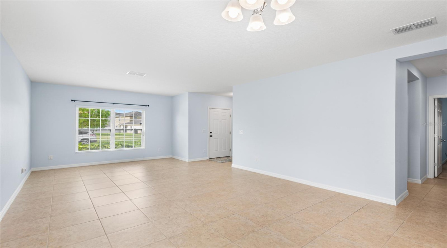 LIVING ROOM & DINING ROOM. VIEW TOWARDS FRONT DOOR. ALCOVE TO RIGHT LEADS TO PRIMARY BEDROOM