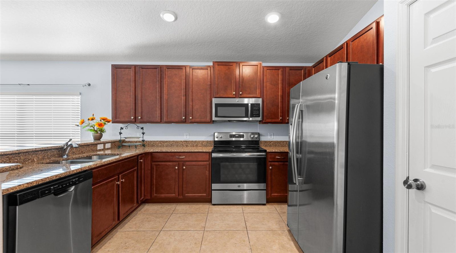 KITCHEN FEATURES WOOD CABINETRY, GRANITE COUNTERTOPS & SS APPLIANCES