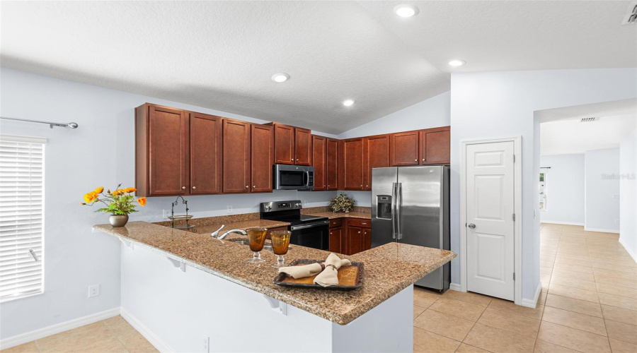 KITCHEN ALSO FEATURES BREAKFAST COUNTER, PANTRY CLOSET & RECESSED LIGHTING!
