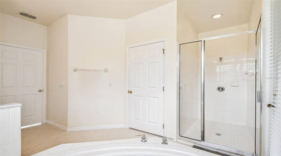 The main-floor primary suite features brand new hardwood flooring, a large ensuite bathroom with dual sinks, a garden tub, walk-in shower, and a private water closet.